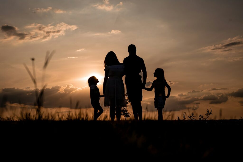 Família reunida em um campo ao pôr do sol